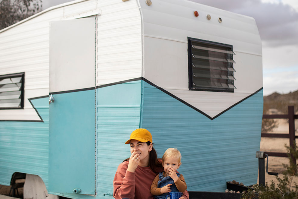 Mãe e filho sorrindo em frente a trailer colorido