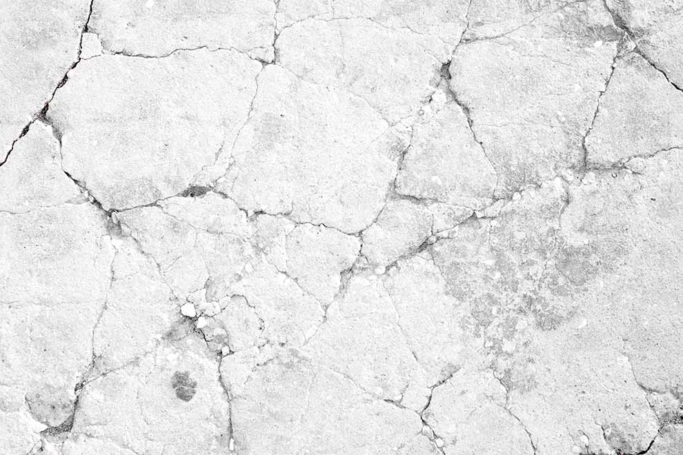 pequenas rachaduras em parede branca de pedra e concreto
