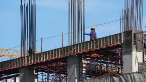 Trabalhador em cima de estrutura em construção